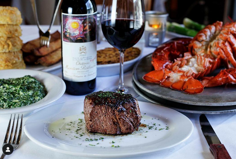 Steak, Wine and Lobster on table