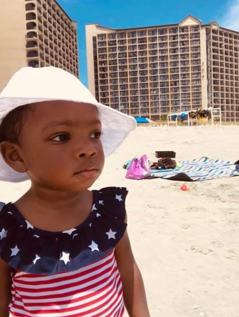 little baby with hat on beach