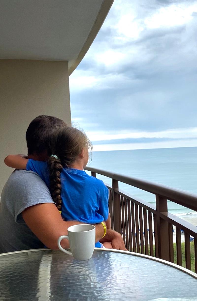 dad holding baby on balcony