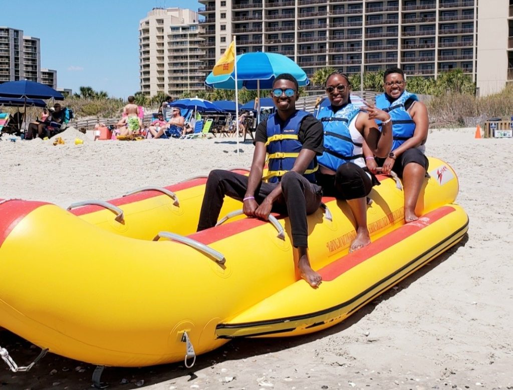 Family on a banana boat on the beach