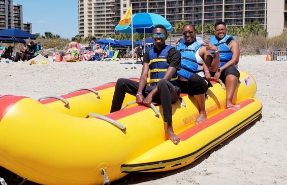 Family on a banana boat on the beach